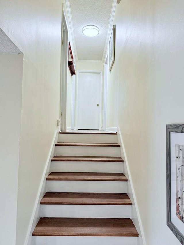 stairs featuring a textured ceiling