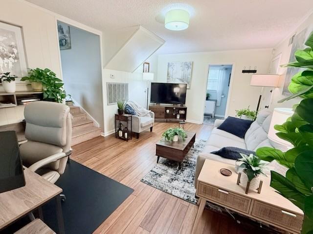 living room featuring a textured ceiling and light wood-type flooring