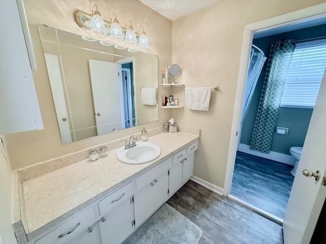 bathroom featuring vanity, hardwood / wood-style floors, and toilet