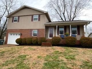 tri-level home featuring a garage and a front lawn