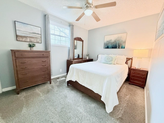 carpeted bedroom with ceiling fan and a textured ceiling