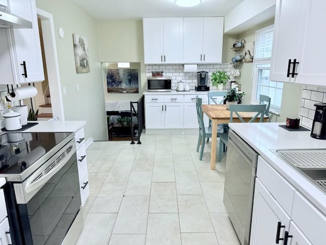 kitchen featuring light tile patterned floors, decorative backsplash, white cabinets, and appliances with stainless steel finishes