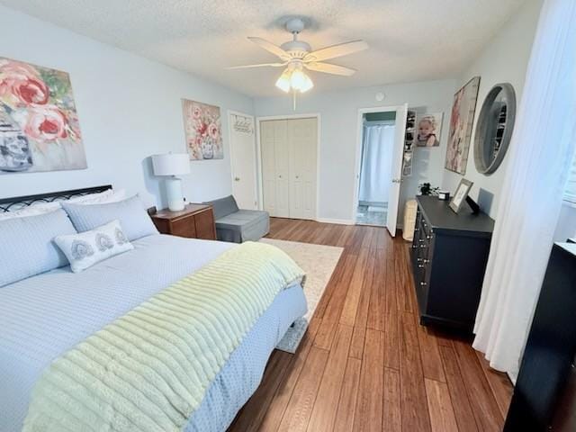 bedroom with ceiling fan, dark hardwood / wood-style floors, a closet, and a textured ceiling