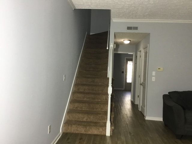 stairs with hardwood / wood-style flooring and a textured ceiling