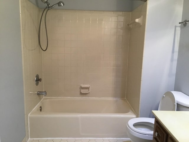 full bathroom featuring tiled shower / bath, vanity, and toilet