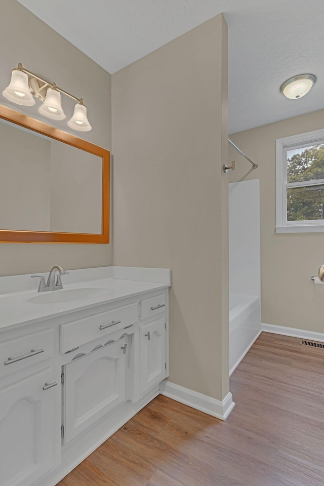 bathroom with vanity, shower / washtub combination, and hardwood / wood-style floors