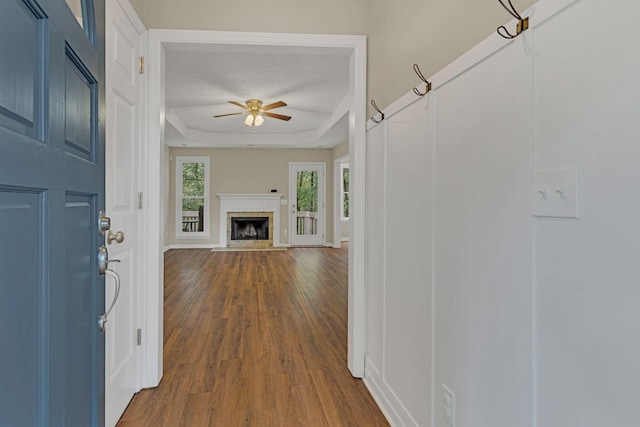 hall with hardwood / wood-style floors and a tray ceiling