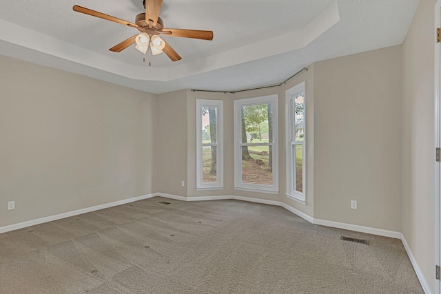 unfurnished room with light carpet, a raised ceiling, and ceiling fan