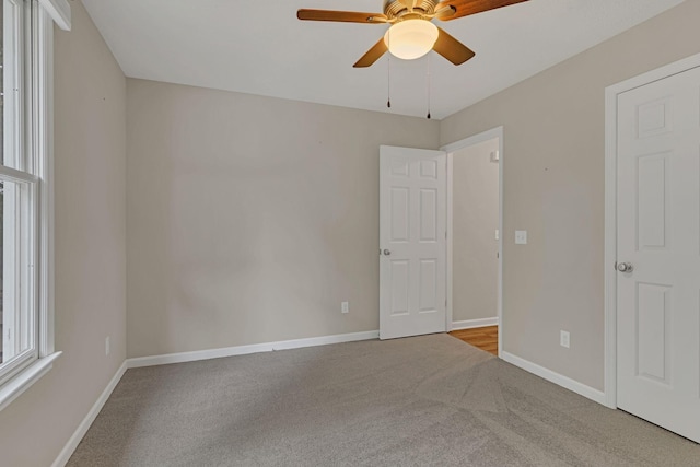 carpeted empty room featuring ceiling fan