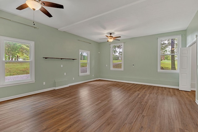 unfurnished room featuring hardwood / wood-style flooring, ceiling fan, and a wealth of natural light