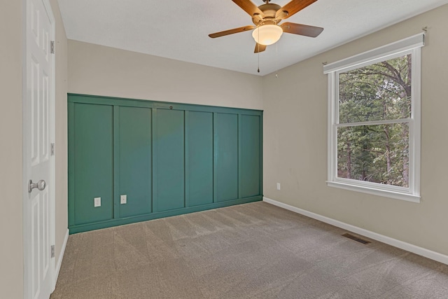 unfurnished bedroom with light carpet, a textured ceiling, and ceiling fan