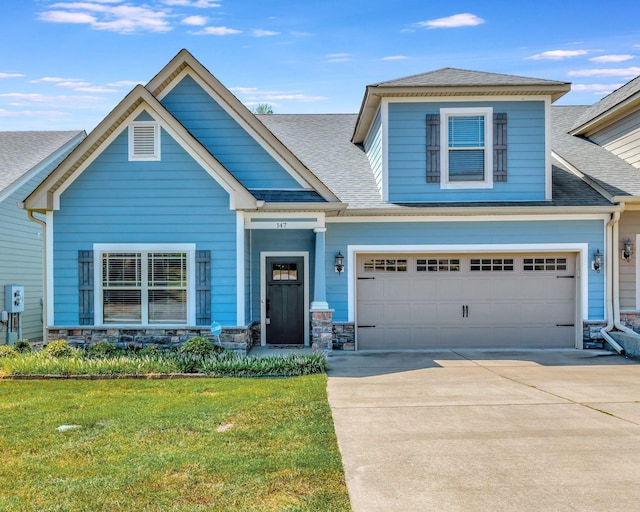 craftsman inspired home featuring a garage and a front lawn