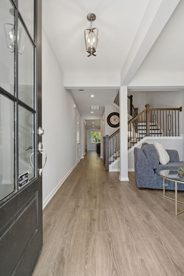 foyer with hardwood / wood-style flooring and a notable chandelier