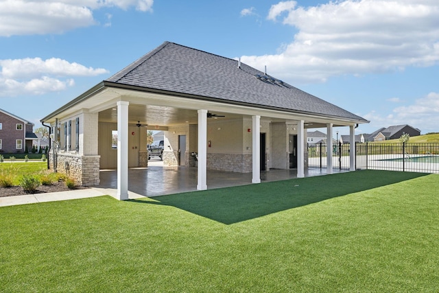 rear view of house with ceiling fan, a patio area, and a lawn