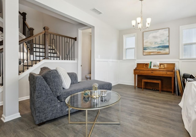 sitting room with a healthy amount of sunlight, a notable chandelier, and dark hardwood / wood-style floors