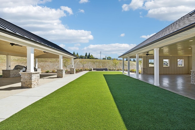 view of yard with a patio area, ceiling fan, and exterior kitchen