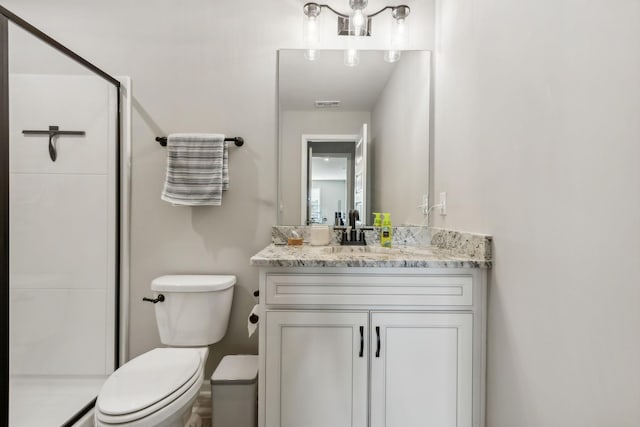 bathroom with vanity, a shower with shower door, and toilet