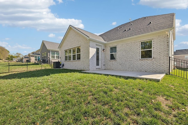 back of house featuring central AC, a patio area, and a lawn