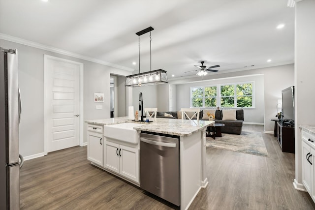 kitchen with appliances with stainless steel finishes, decorative light fixtures, an island with sink, sink, and white cabinets