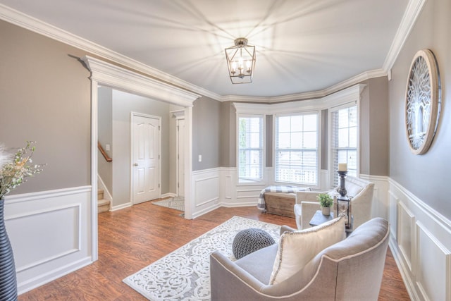 living area with dark hardwood / wood-style flooring, a notable chandelier, and ornamental molding