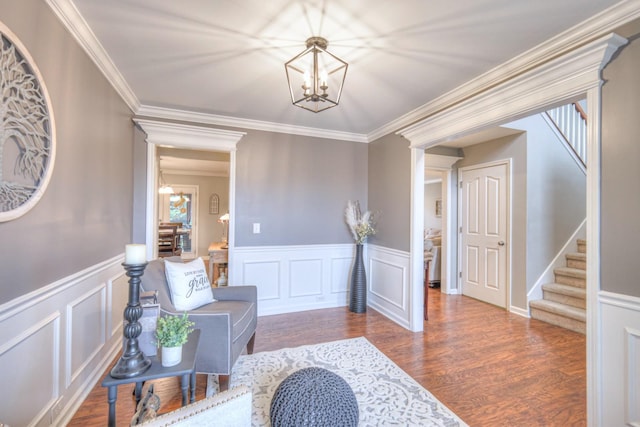 living area with crown molding, dark hardwood / wood-style floors, and a chandelier