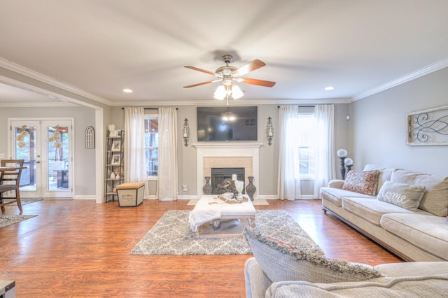 living room featuring ornamental molding, a healthy amount of sunlight, hardwood / wood-style floors, and french doors