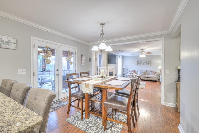 dining area featuring french doors, wood-type flooring, and crown molding