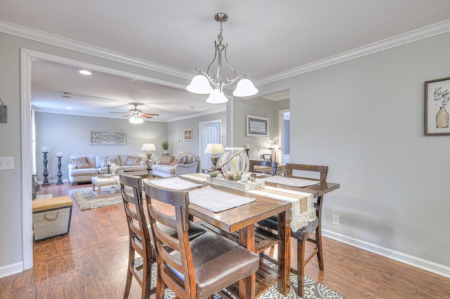 dining space featuring dark hardwood / wood-style flooring, crown molding, and ceiling fan with notable chandelier