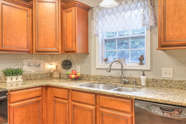 kitchen with dishwasher, sink, and light stone countertops