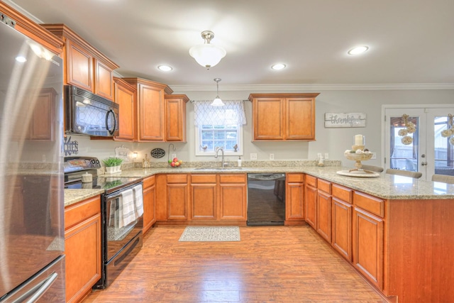 kitchen with sink, crown molding, light hardwood / wood-style flooring, pendant lighting, and black appliances