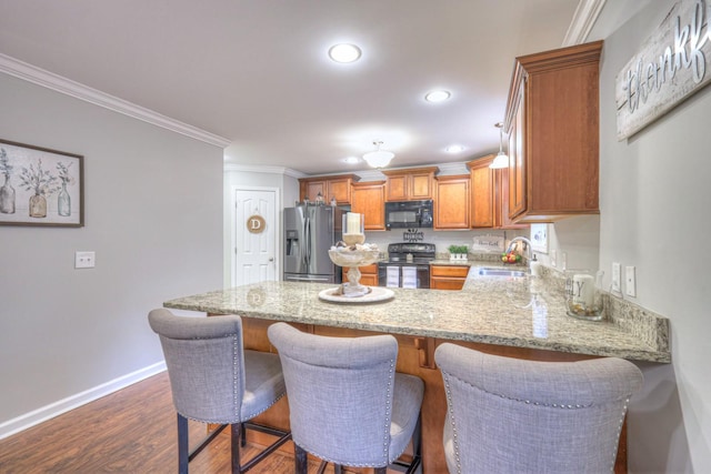 kitchen featuring dark wood-type flooring, sink, crown molding, kitchen peninsula, and black appliances