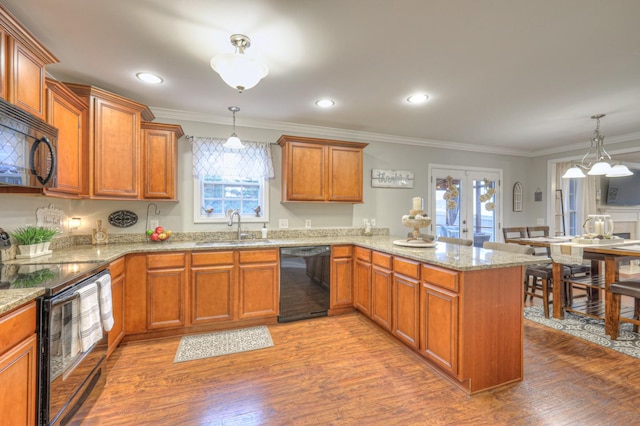 kitchen with french doors, sink, kitchen peninsula, pendant lighting, and black appliances