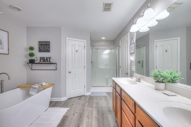 bathroom with independent shower and bath, vanity, and hardwood / wood-style flooring