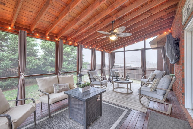 sunroom / solarium featuring ceiling fan, a wealth of natural light, lofted ceiling with beams, and wooden ceiling