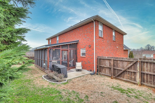 back of house with a patio, a sunroom, and a lawn