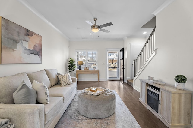 living room featuring crown molding, ceiling fan, and dark hardwood / wood-style flooring