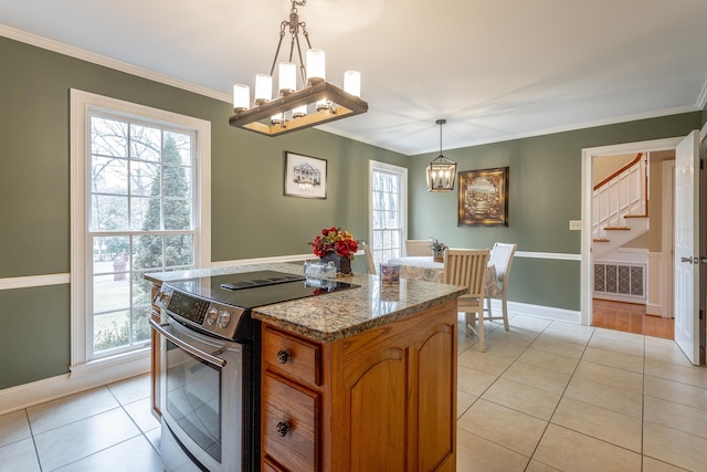 kitchen with stainless steel electric stove, pendant lighting, ornamental molding, light tile patterned floors, and an inviting chandelier