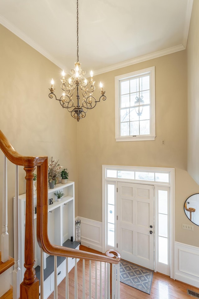 entrance foyer featuring ornamental molding and light hardwood / wood-style floors