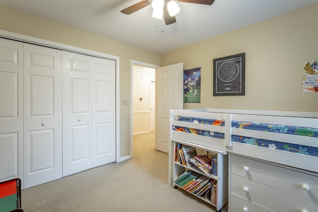 carpeted bedroom featuring ceiling fan and a closet