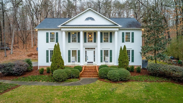 neoclassical home featuring a front yard