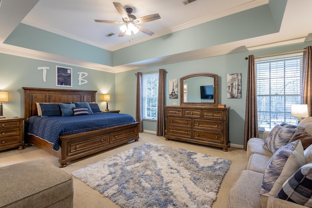 bedroom featuring ornamental molding, light carpet, ceiling fan, and a tray ceiling