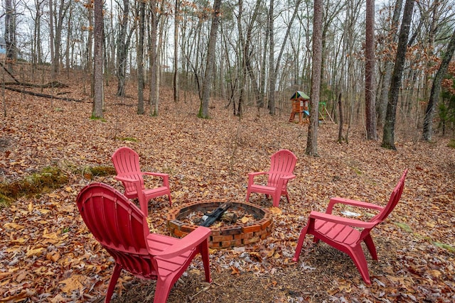 exterior space with a playground and an outdoor fire pit