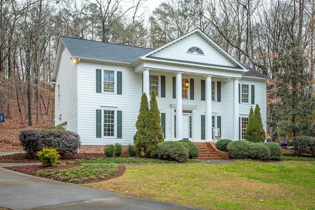 neoclassical / greek revival house featuring a front lawn