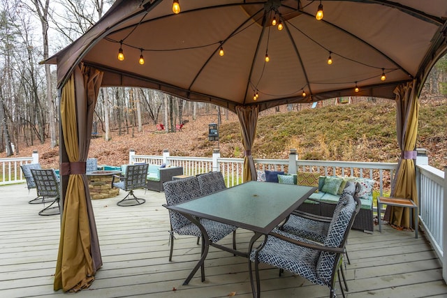 deck with a gazebo and an outdoor living space with a fire pit