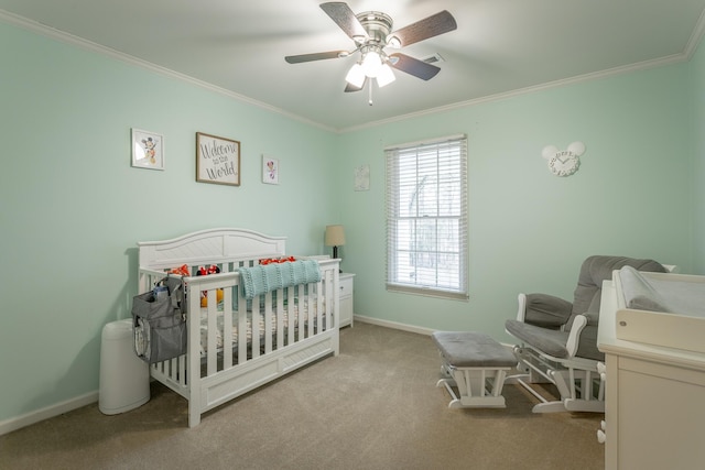 bedroom with ornamental molding, a nursery area, light colored carpet, and ceiling fan