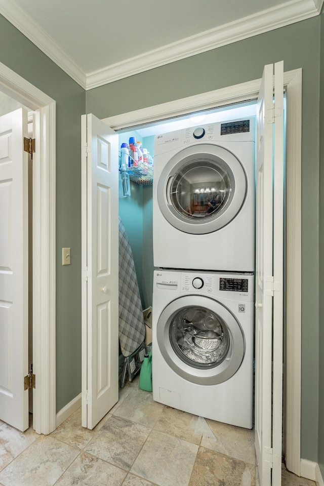 clothes washing area with stacked washer / drying machine and crown molding