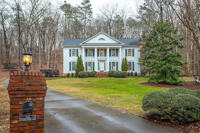 greek revival inspired property featuring a front yard