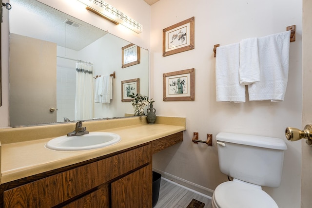 bathroom with hardwood / wood-style flooring, vanity, a shower with shower curtain, and toilet