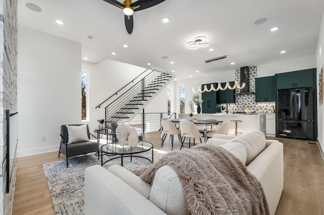 living room with ceiling fan and light hardwood / wood-style floors