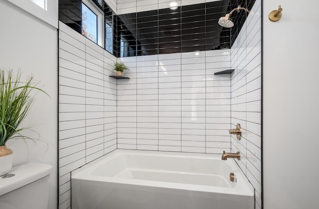 bathroom featuring toilet and tiled shower / bath combo